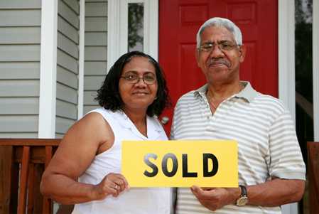 Image of an elderly couple holding a sales who had to sell house fast in Dayton